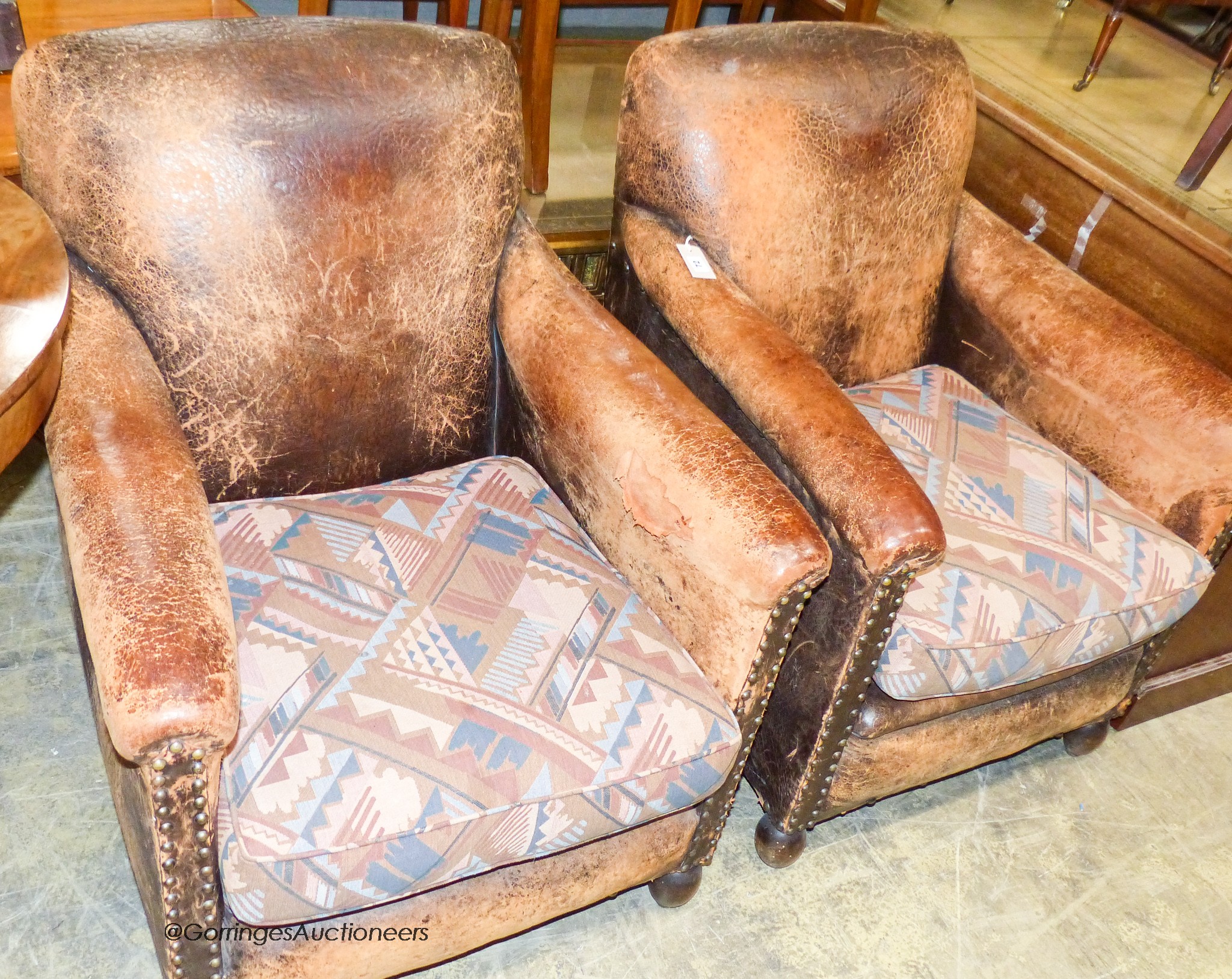 A pair of tan leather upholstered armchairs, width 70cm, depth 80cm, height 85cm